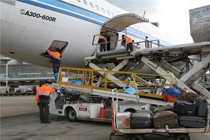 Les bagos déchargent les bagages à l'arrière d'un avion. 
